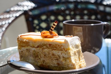 Photo of Tasty dessert and cup of fresh aromatic coffee on glass table outdoors, closeup