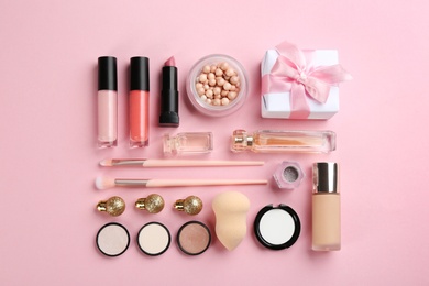 Flat lay composition with decorative cosmetic products on pink background. Winter care