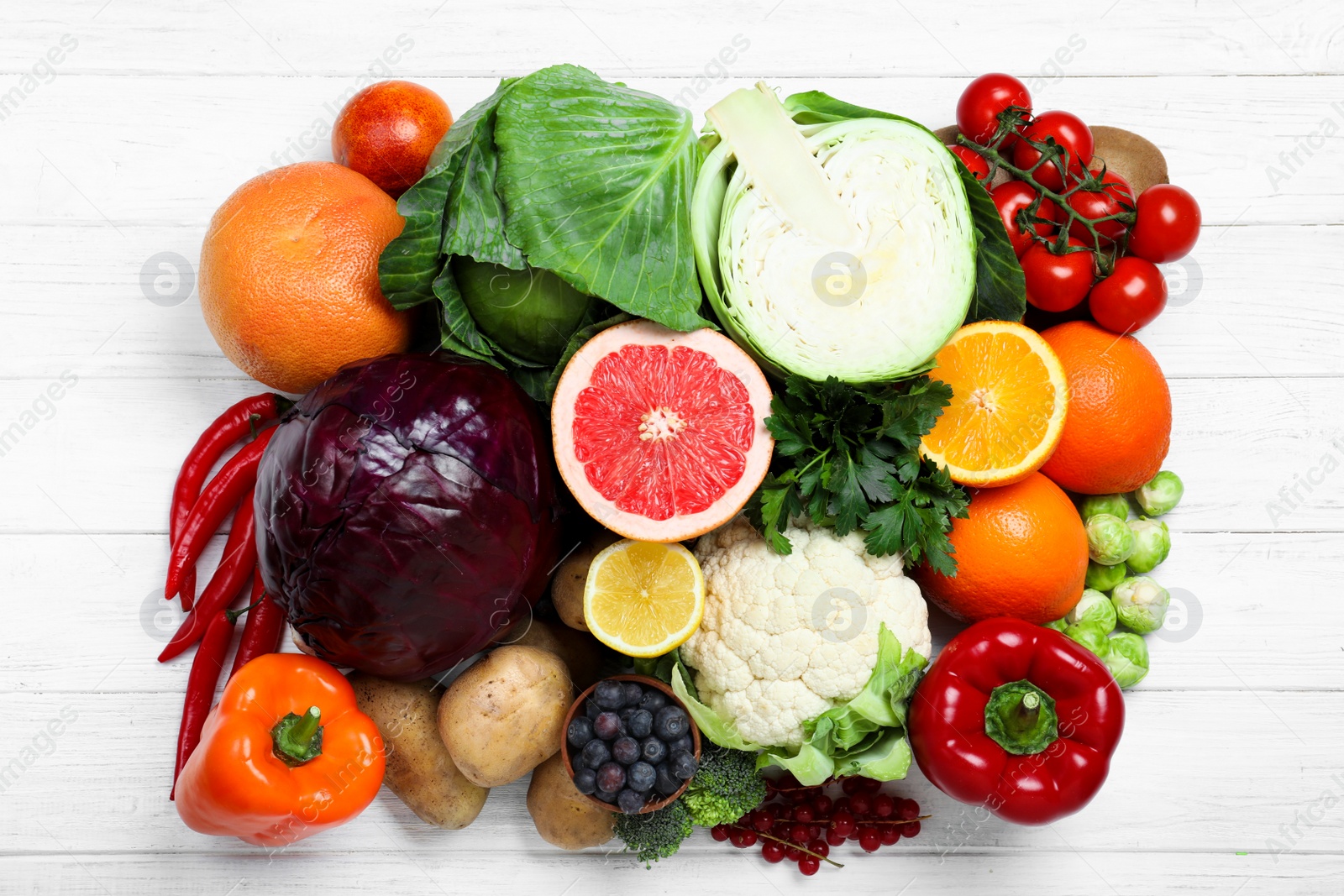 Photo of Fresh products rich in vitamin C on white wooden table, flat lay