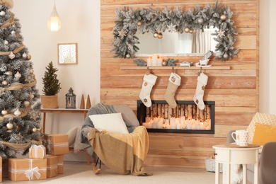Photo of Beautiful Christmas interior of living room with decorative fireplace
