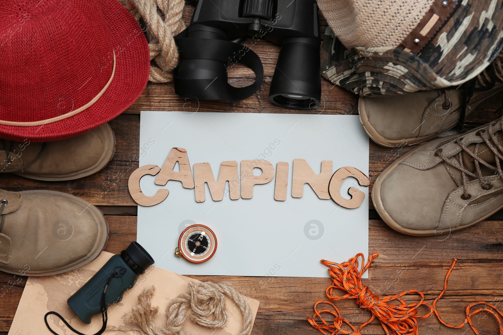 Photo of Flat lay composition with camping equipment on wooden background