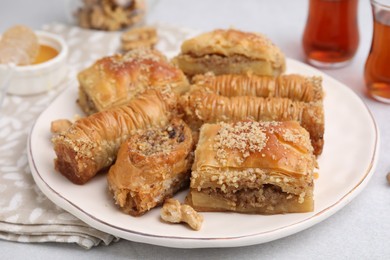 Photo of Eastern sweets. Pieces of tasty baklava on white table, closeup