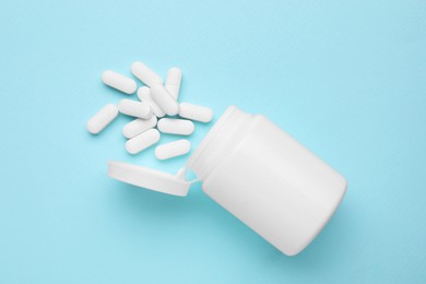 Antidepressants and medical bottle on light blue background, flat lay