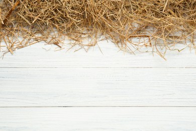 Photo of Dried hay on white wooden background, flat lay. Space for text