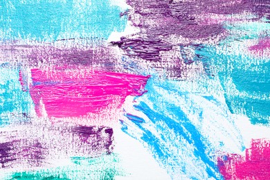 Photo of Strokes of colorful acrylic paints on white canvas, closeup