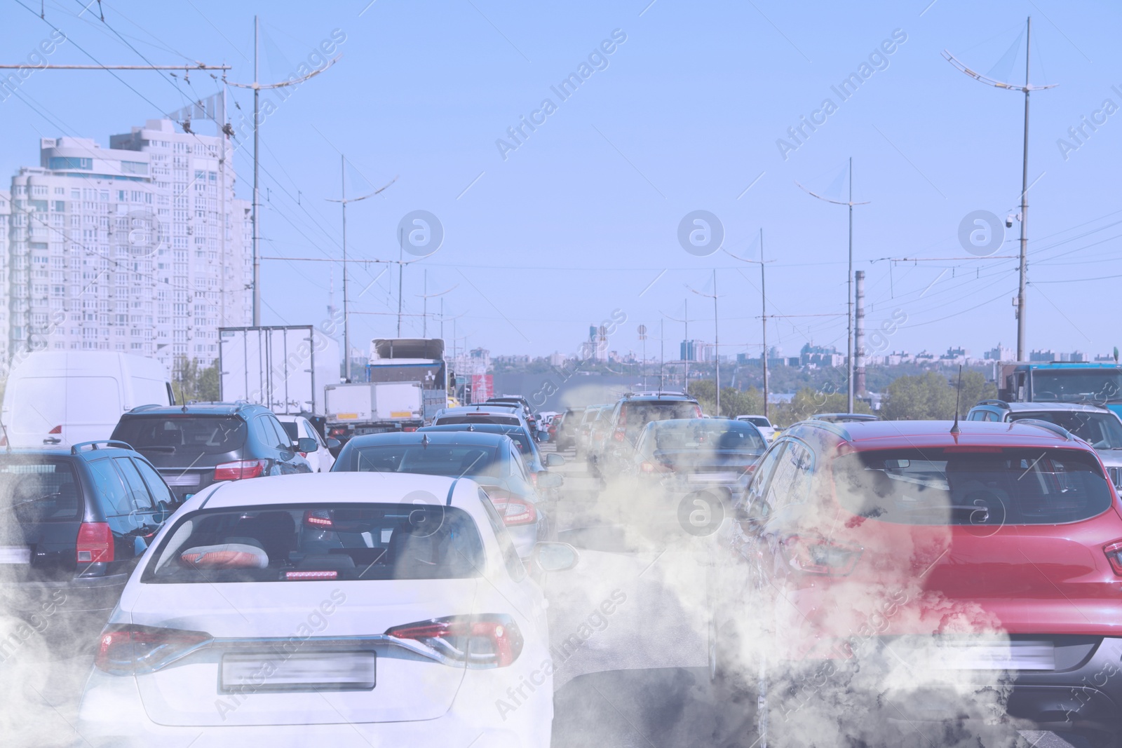 Image of Environmental pollution. Air contaminated with fumes in city. Cars surrounded by exhaust on road