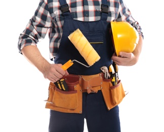 Photo of Construction worker with hard hat, paint roller and tool belt on white background, closeup