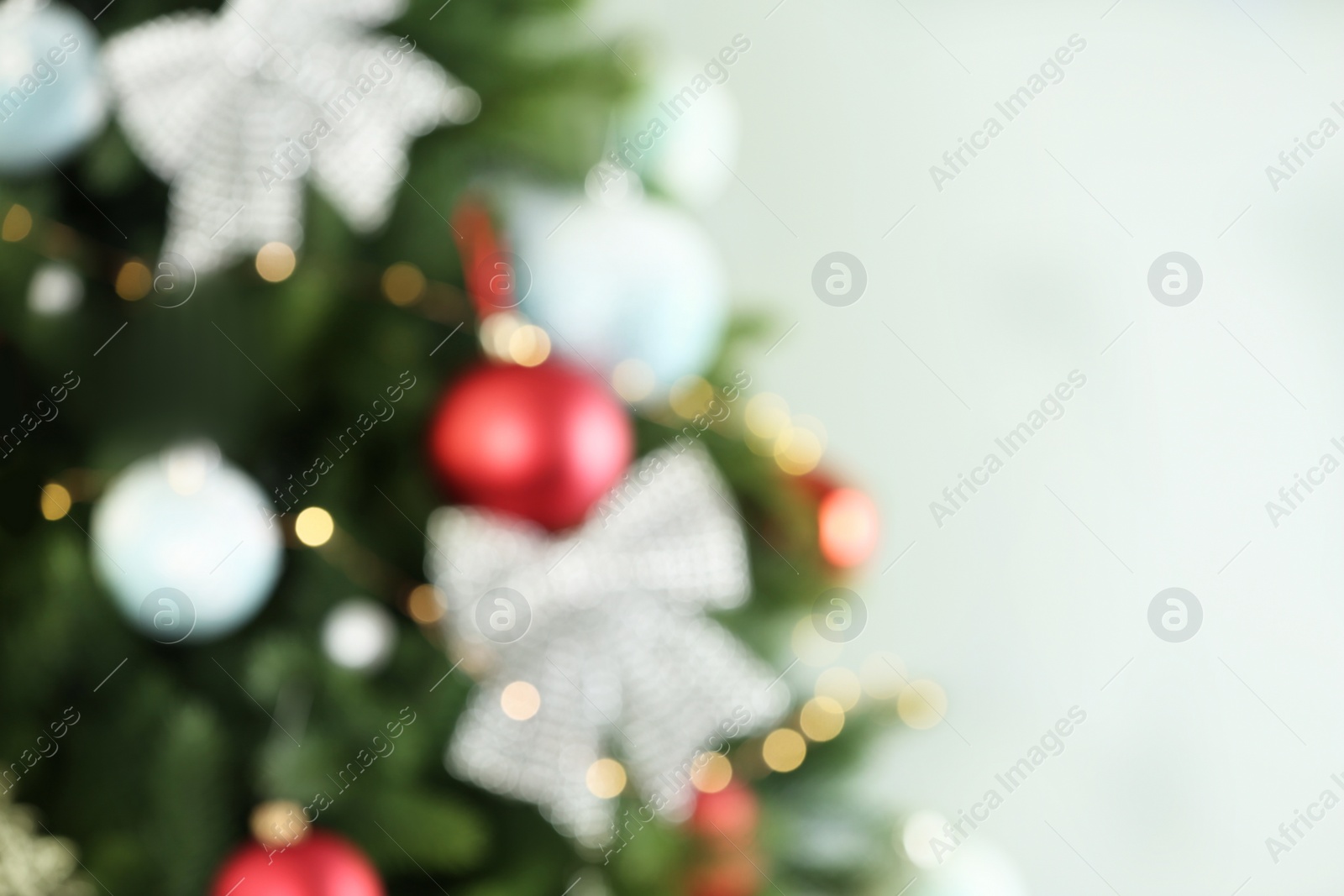 Photo of Beautiful Christmas tree with lights against grey background, blurred view. Space for text