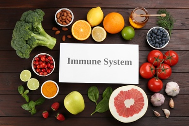 Card with phrase Immune System and fresh products on wooden table, flat lay