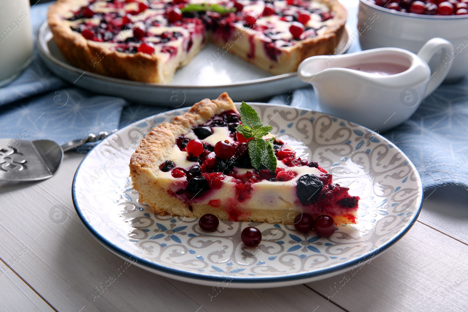 Photo of Piece of delicious currant pie served on white wooden table