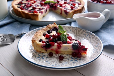 Piece of delicious currant pie served on white wooden table