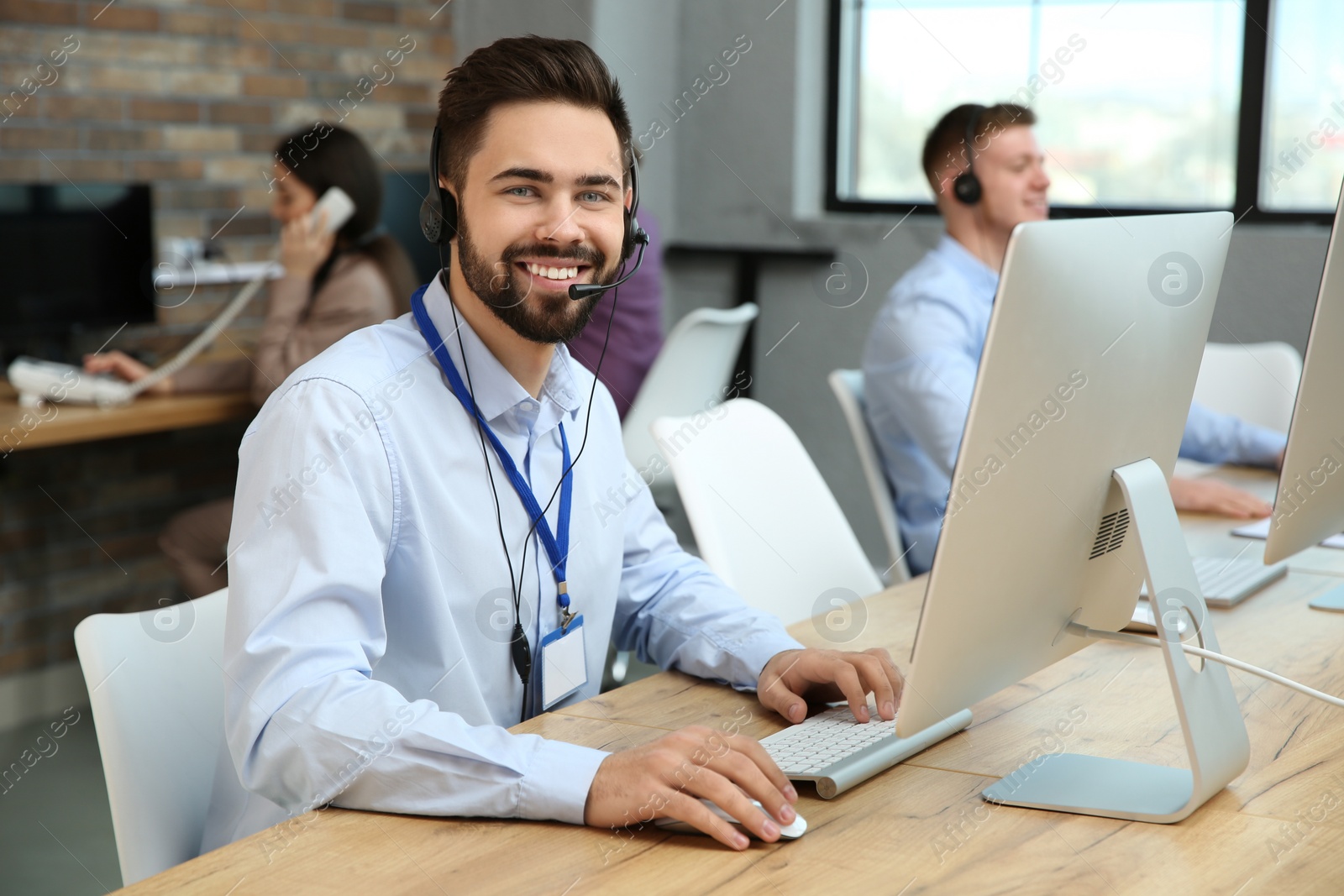 Photo of Technical support operator working with colleagues in office