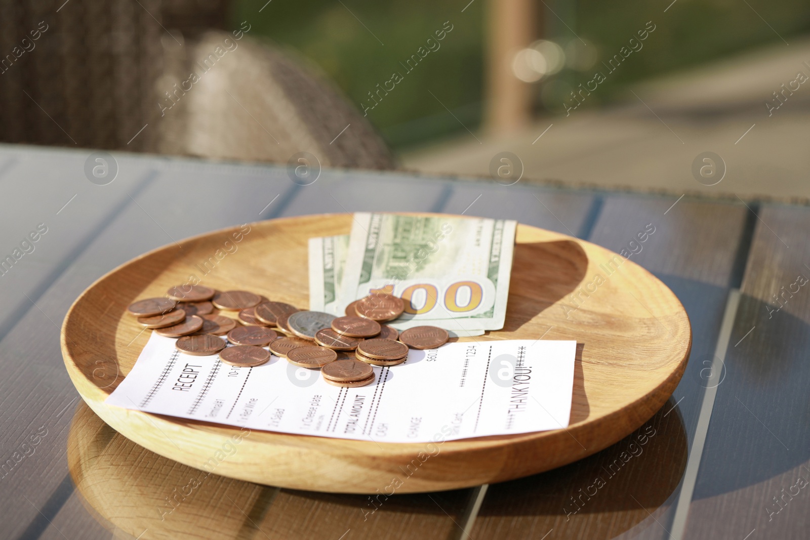 Photo of Wooden plate with payment for order and receipt on table, closeup. Leave tip