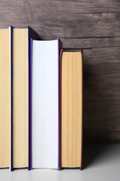 Collection of different books on white shelf, space for text