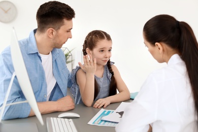 Photo of Young man with his daughter having appointment at child psychologist office