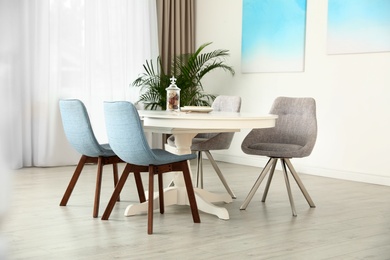 Photo of Stylish room interior with dining table and chairs