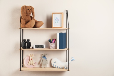 Shelves with toys and kids stuff in child room. Space for text