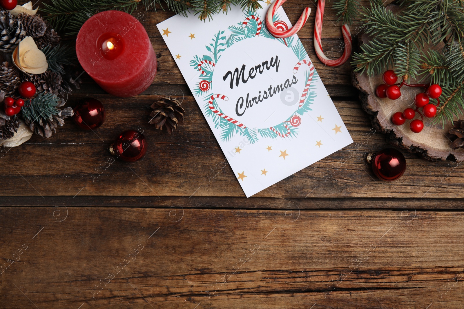 Photo of Flat lay composition with Christmas card and festive decor on wooden background, space for text