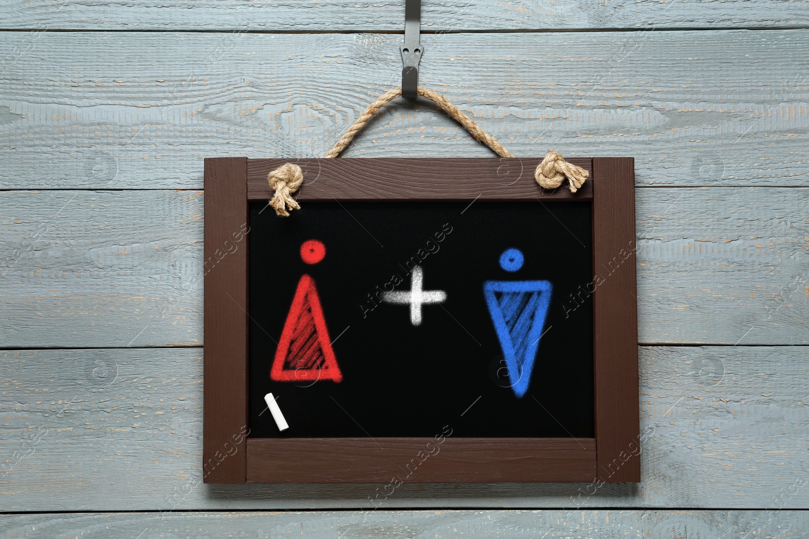 Image of Sex education. Small black chalkboard with drawn female and male figures on wooden background, top view