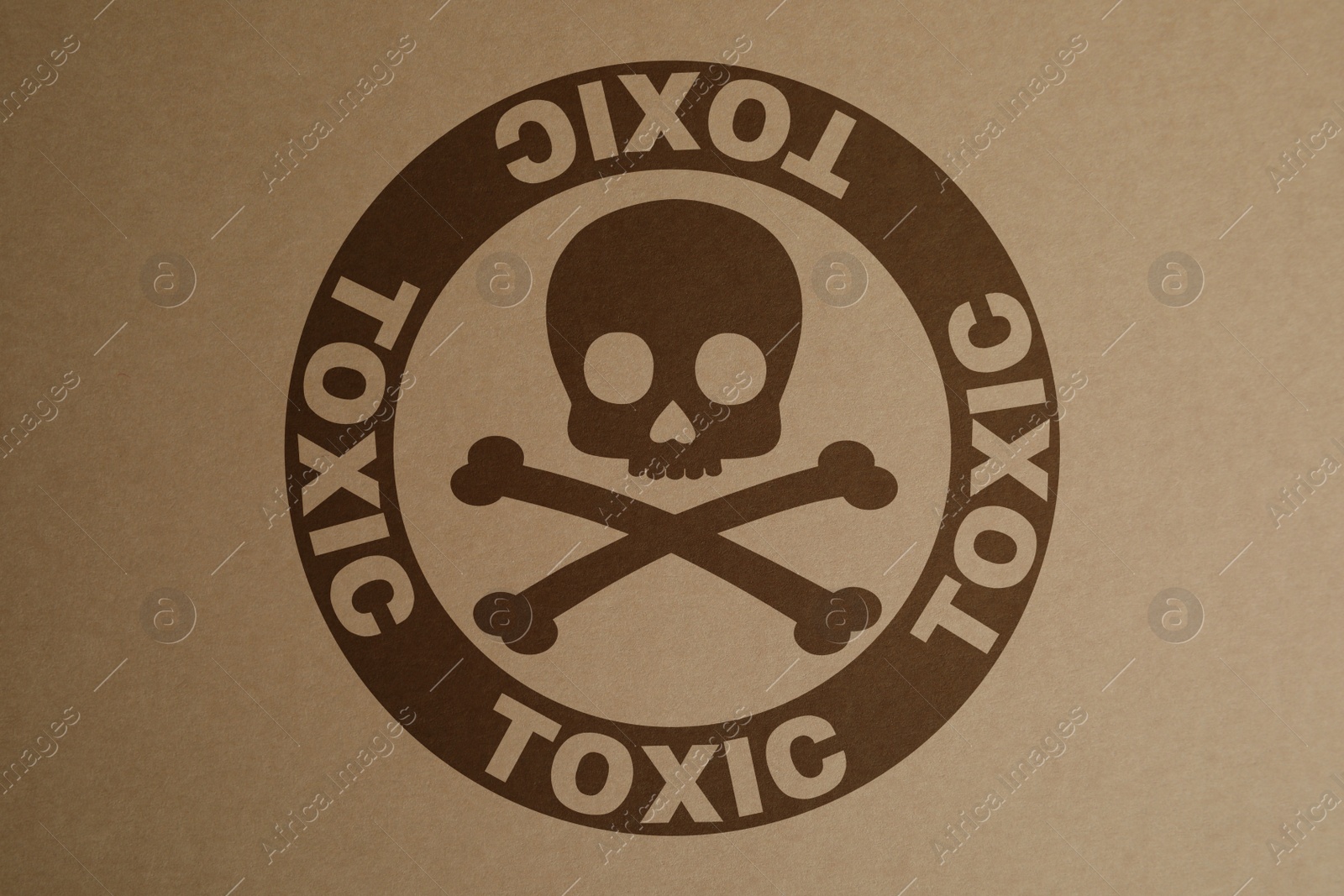 Image of Hazard warning sign (skull-and-crossbones symbol and word TOXIC) on kraft paper, top view