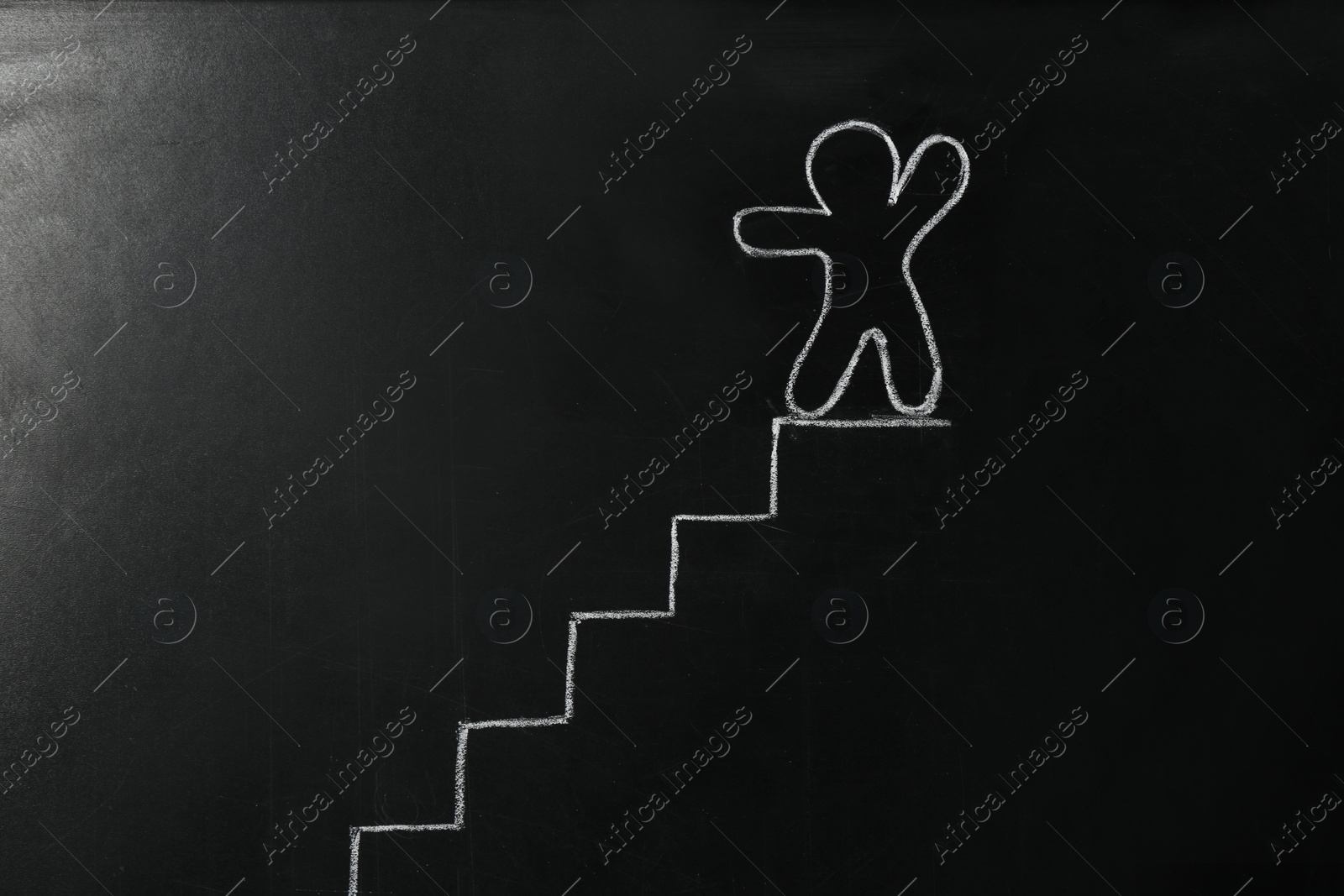 Photo of Drawing of human figure and stairs on chalkboard. Career promotion concept
