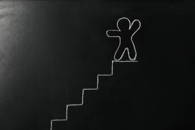 Drawing of human figure and stairs on chalkboard. Career promotion concept