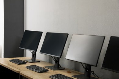 Open office interior. Modern workplaces with computers near light grey wall