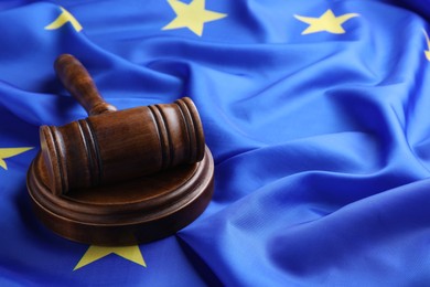 Photo of Wooden judge's gavel on flag of European Union, space for text