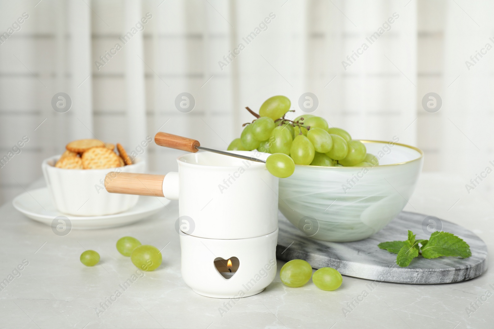 Photo of Fondue pot and products on table indoors