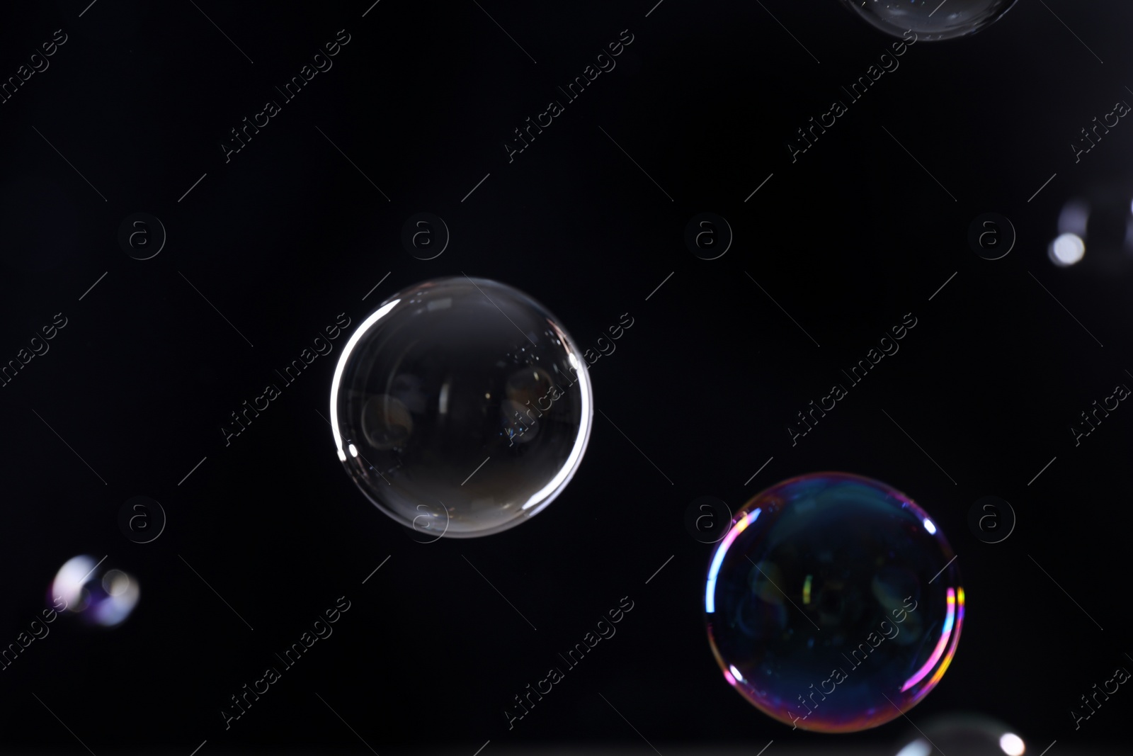 Photo of Beautiful transparent soap bubbles on dark background