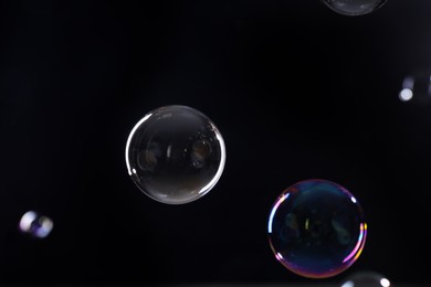 Photo of Beautiful transparent soap bubbles on dark background