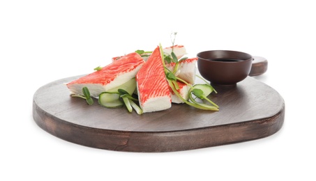 Serving board with fresh crab sticks, cucumber and soy sauce isolated on white