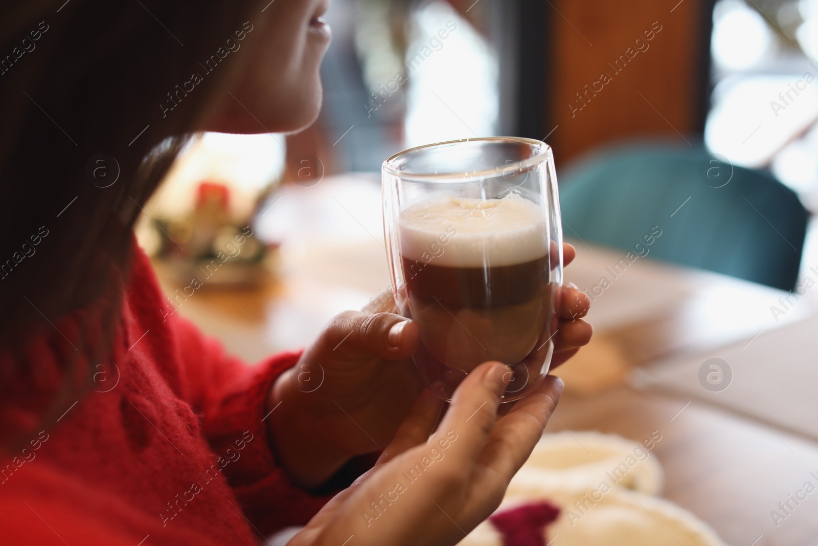 Photo of Woman with fresh morning coffee at table in cafe, closeup