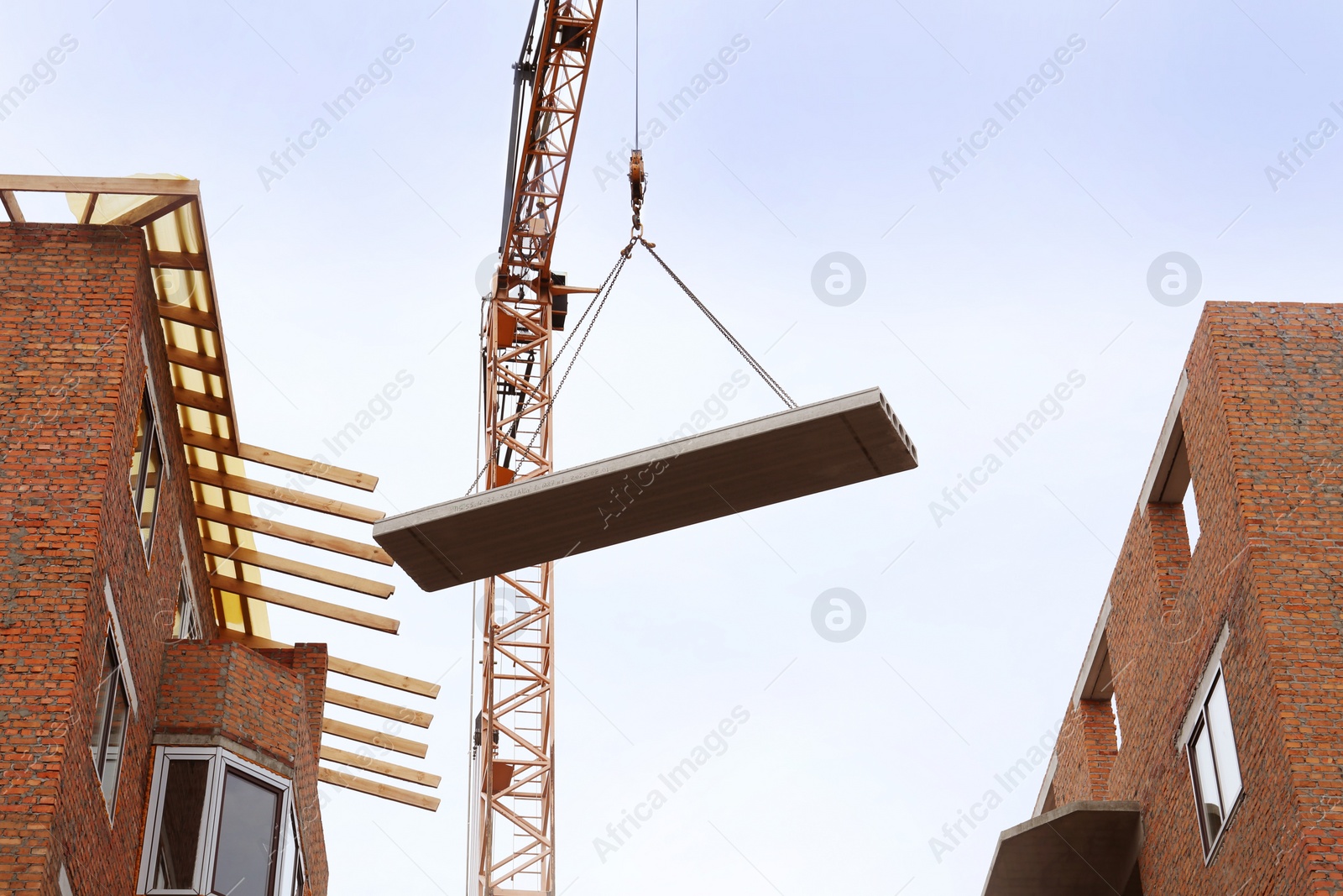Photo of Construction site with tower crane near unfinished buildings, low angle view