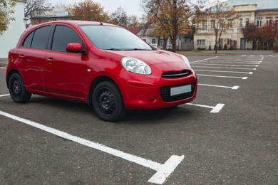 Photo of Modern red car on parking lot outdoors