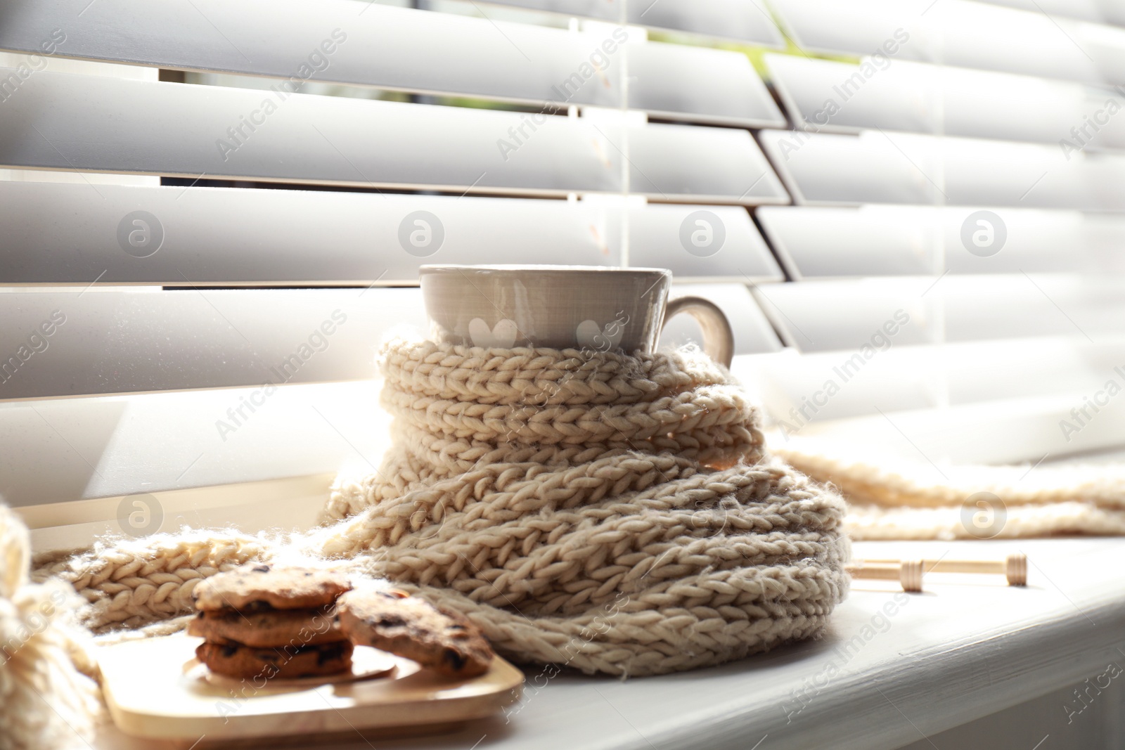 Photo of Cup of hot winter drink and cookies on windowsill indoors