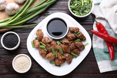 Photo of Tasty soy sauce, roasted meat and ingredients on wooden table, flat lay