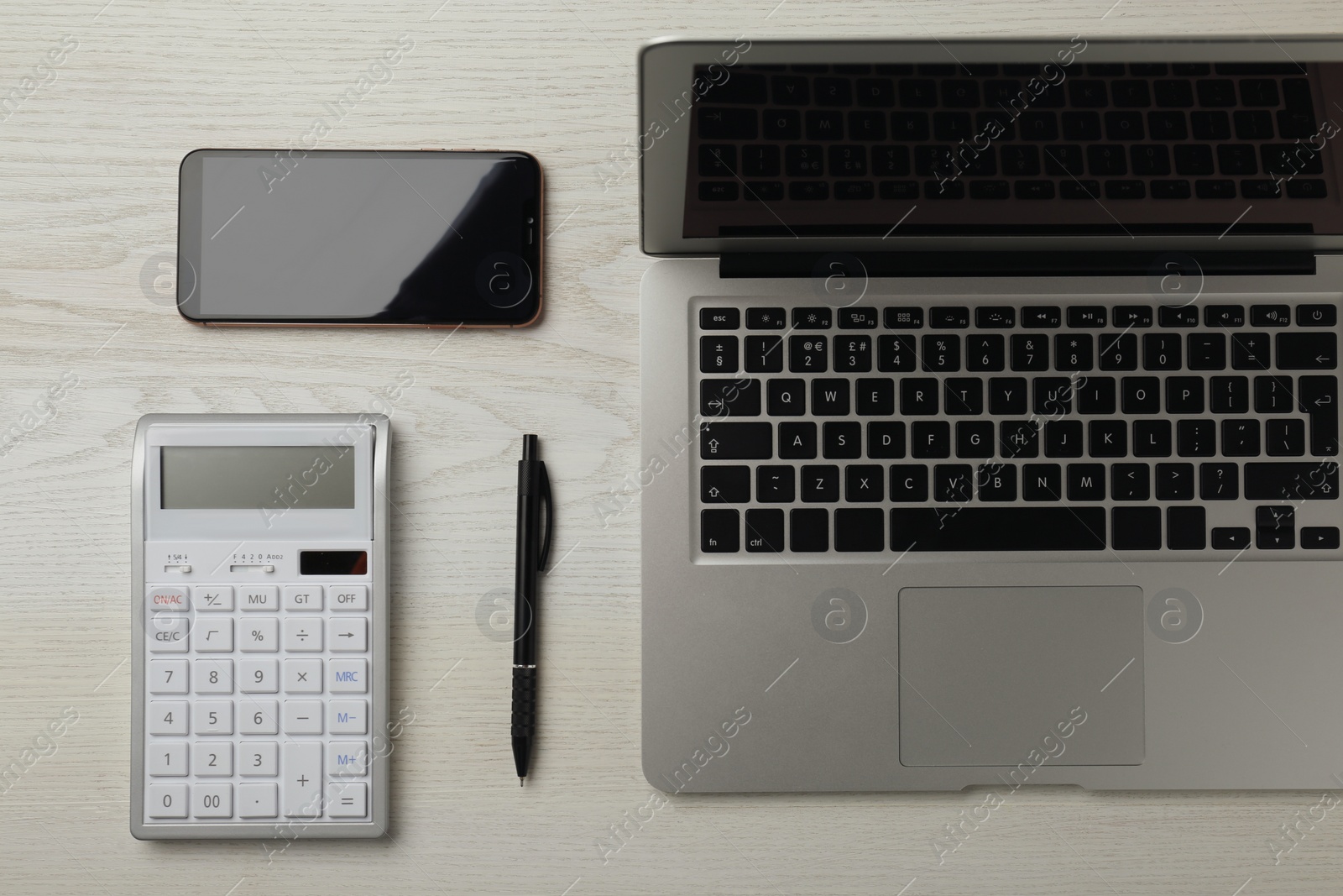 Photo of Modern laptop, pen, calculator and smartphone on wooden table, flat lay