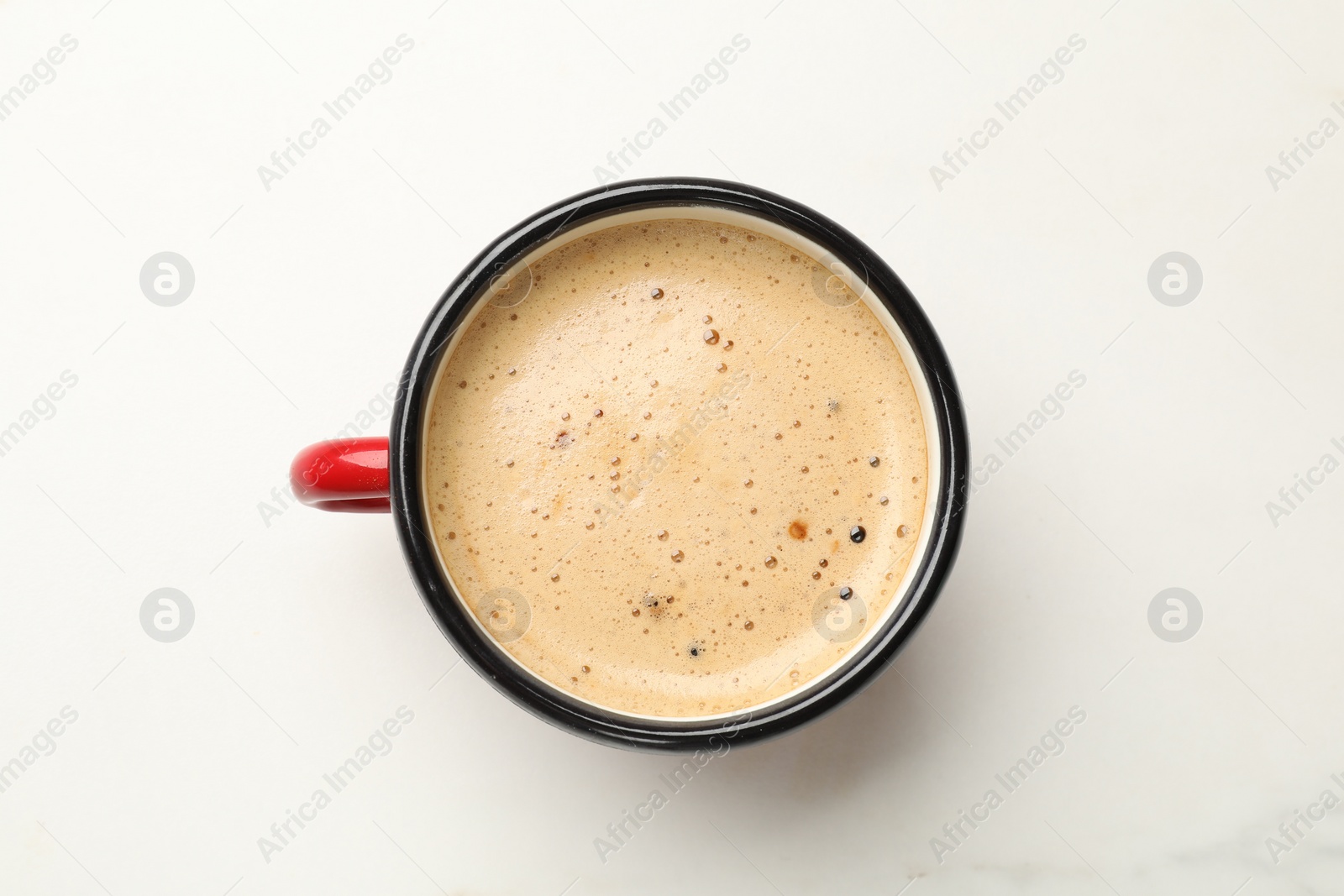 Photo of Cup of aromatic coffee on white table, top view