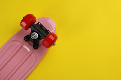 Photo of Skateboard on yellow background, top view. Space for text