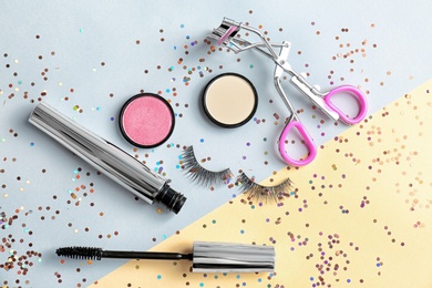 Photo of Flat lay composition with false eyelashes and cosmetic products on color background