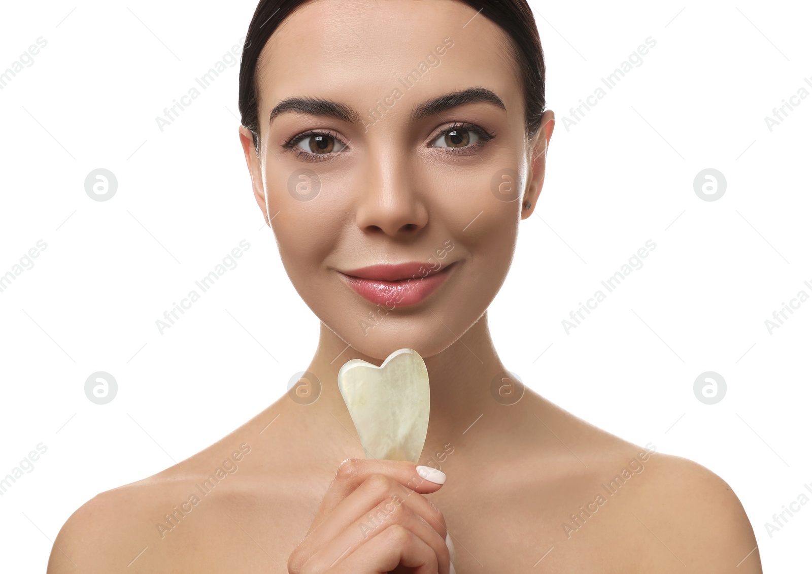 Photo of Beautiful young woman doing facial massage with gua sha tool on white background, closeup