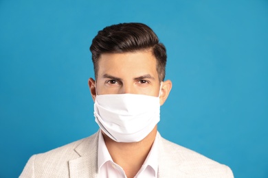 Man in protective face mask on blue background