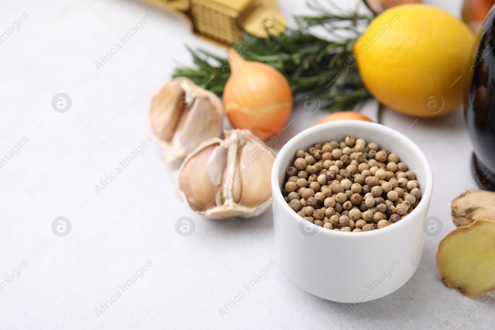 Photo of Aromatic peppercorns and different fresh ingredients for marinade on light grey table. Space for text