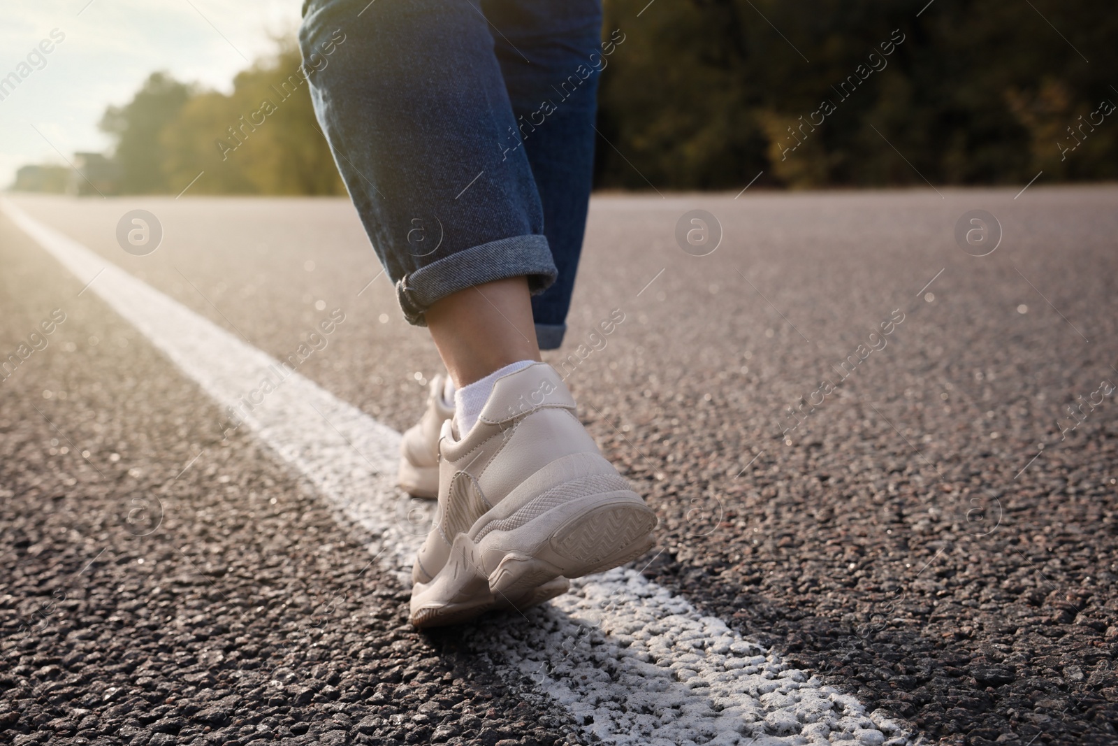 Photo of Woman going along road, closeup of legs