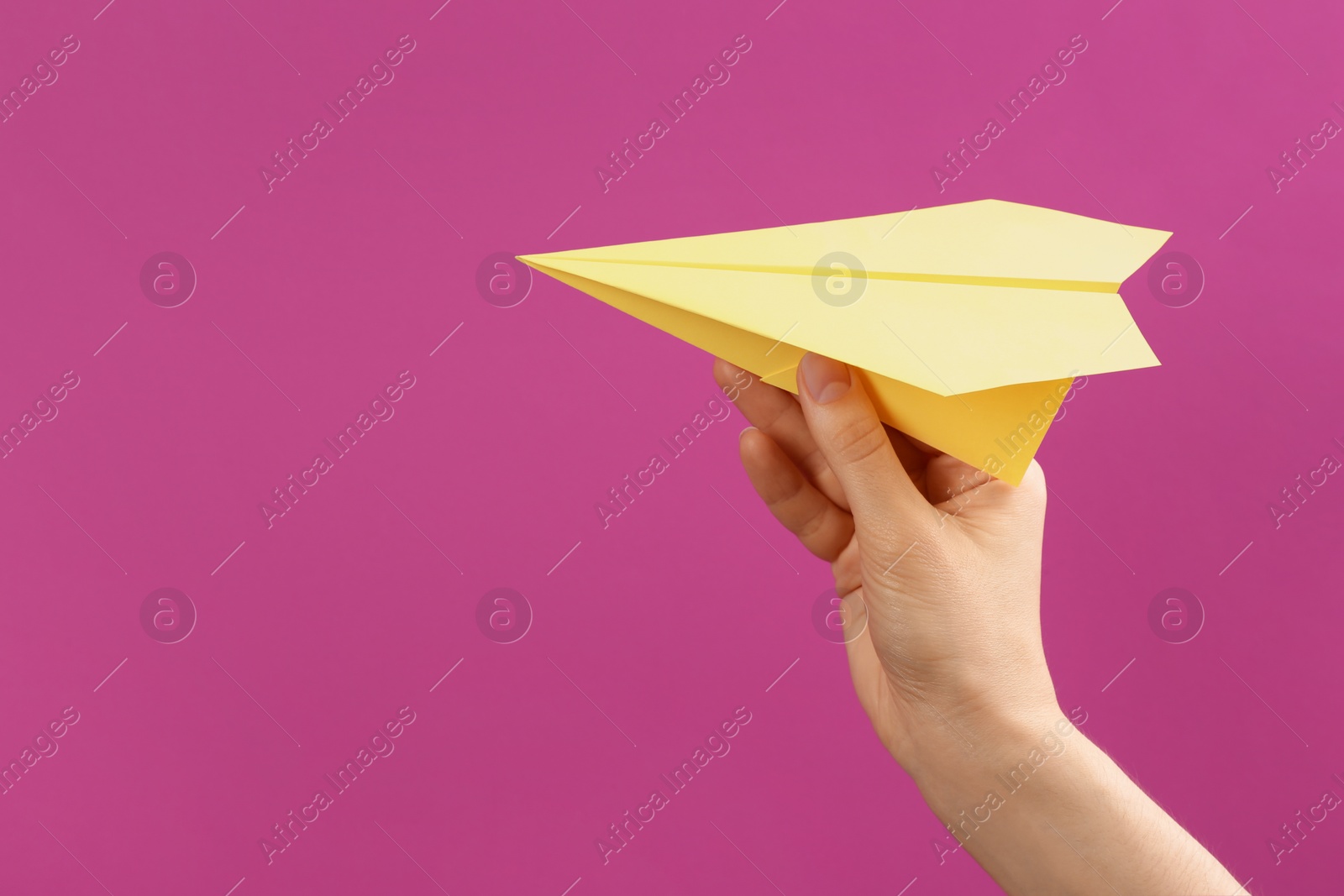 Photo of Woman holding paper plane on purple background, closeup. Space for text