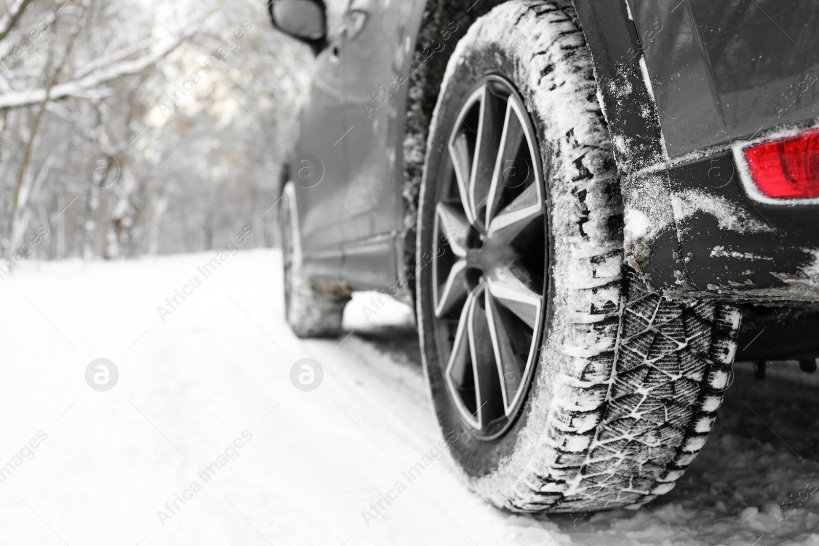 Photo of Snowy country road with car on winter day, closeup