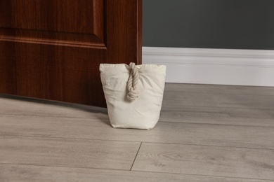 Photo of Stuffed bag holding wooden door at home