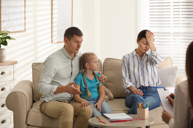 Family on appointment with child psychotherapist indoors