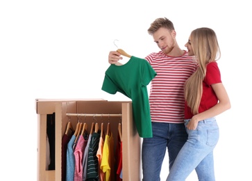 Young couple near wardrobe boxes on white background